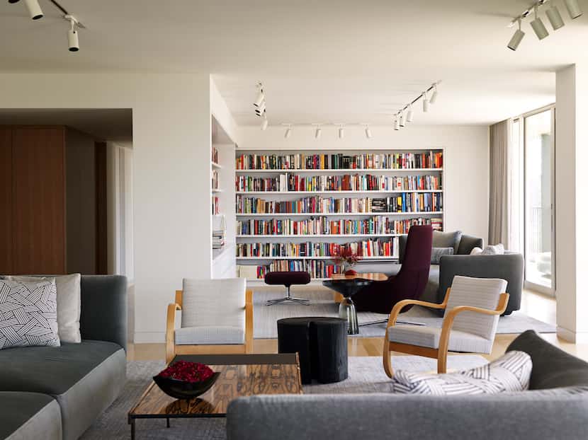 The library and living rooms are continuous, but have visual hints—like the bookshelves and...