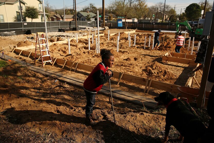 Neighborhood resident Steven Payne, 9, stands with Cruz, founder Daron Babcock's dog, as a...