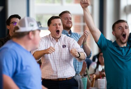 Dallas Baptist University assistant professor of biology Jonathan Cooper, center, celebrates...