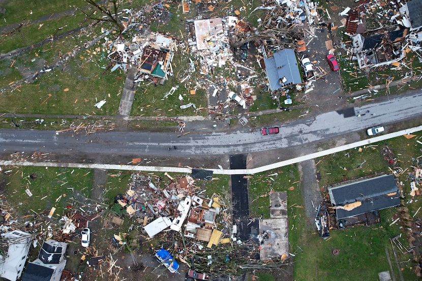 Debris scatters the ground near damaged homes following a severe storm Friday.