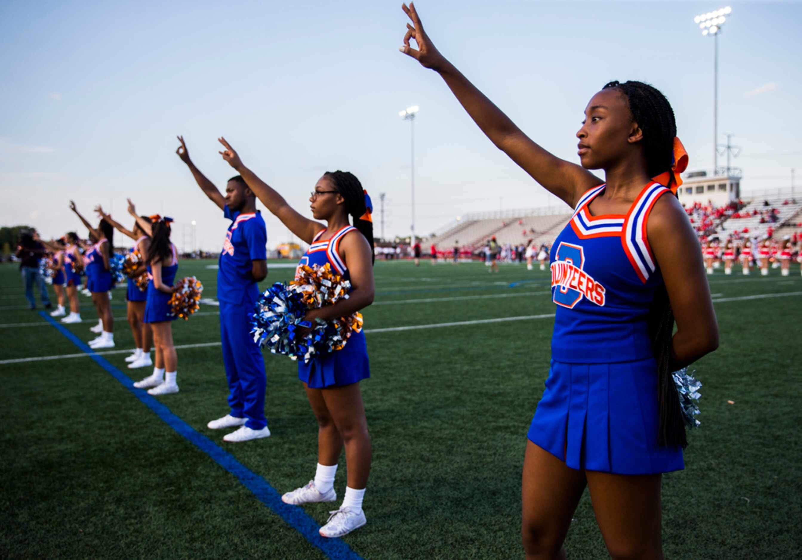 Arlington Bowie cheerleaders sing the school song before a high school football game between...