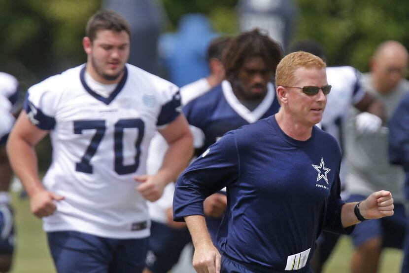 Dallas Cowboys head coach Jason Garrett jogs across the field as offensive tackle Zack...