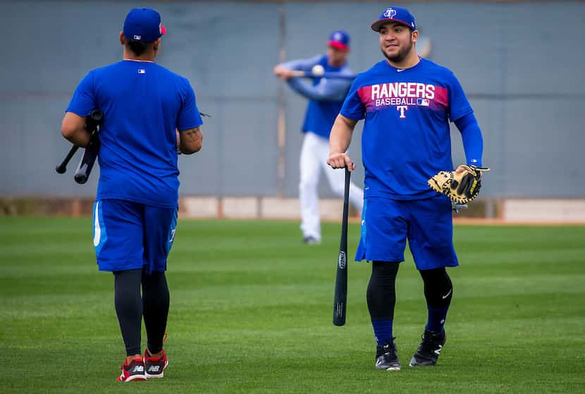 Texas Rangers catchers Jose Trevino (right) and Juan Centeno talk in the outfield after...