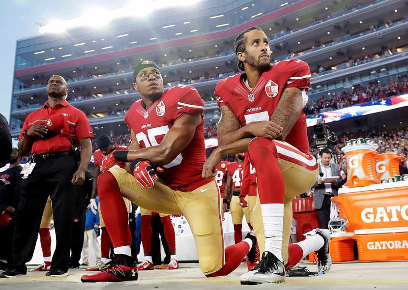 San Francisco 49ers safety Eric Reid (center) and quarterback Colin Kaepernick (right) kneel...