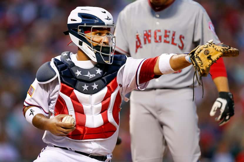 Texas Rangers catcher Carlos Corporan (3) sported a patriotic chest protector and helmet as...