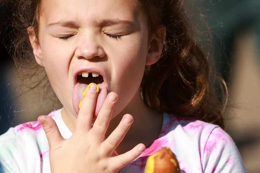 Presleigh Caramela, de 7 años, se lame la mostaza de los dedos después de untarla en su...