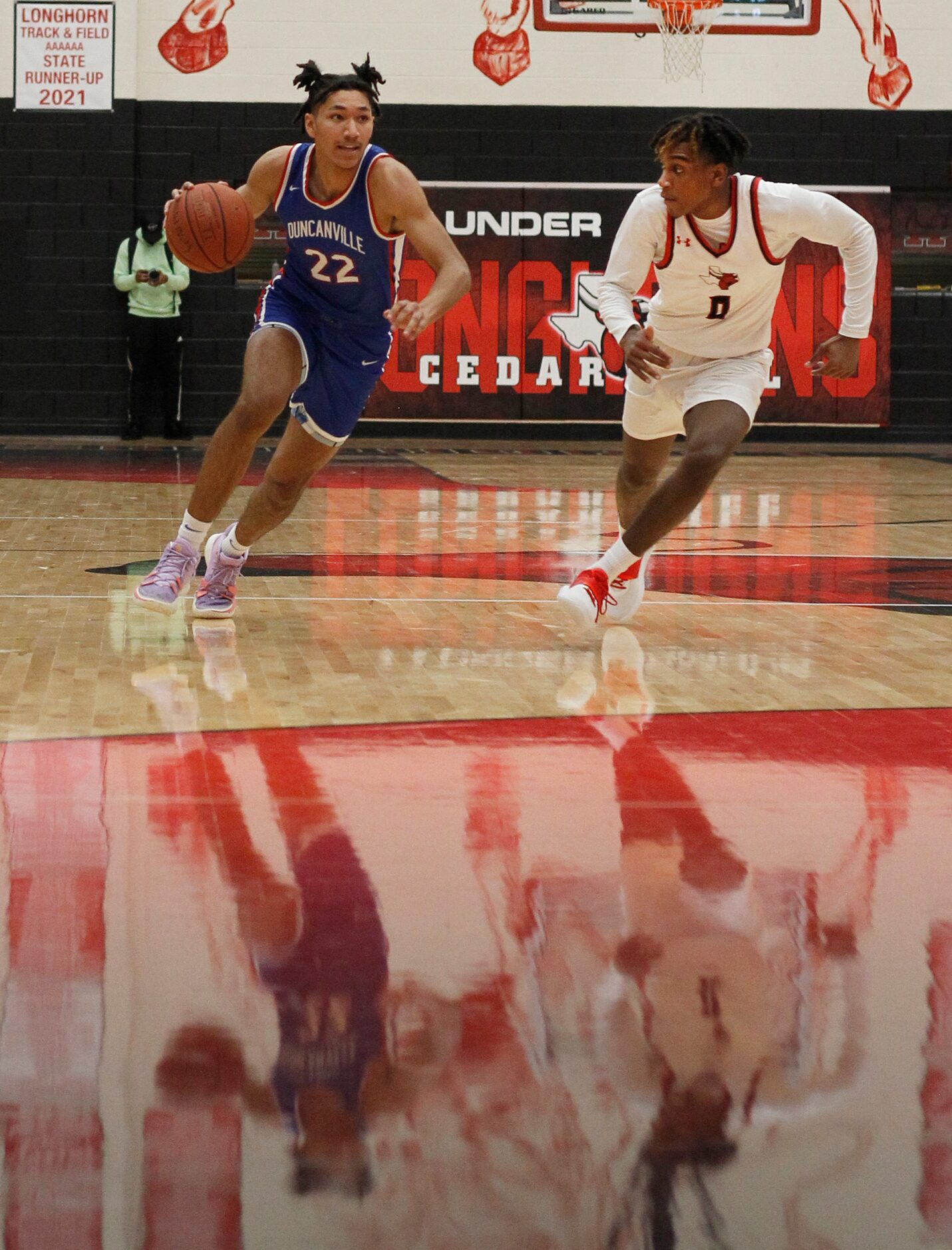 Duncanville guard Davion Sykes (22), left, drives to the basket as he is defended by Cedar...