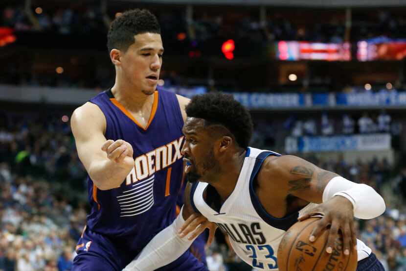 Phoenix Suns guard Devin Booker (1) defends Dallas Mavericks guard Wesley Matthews (23)...