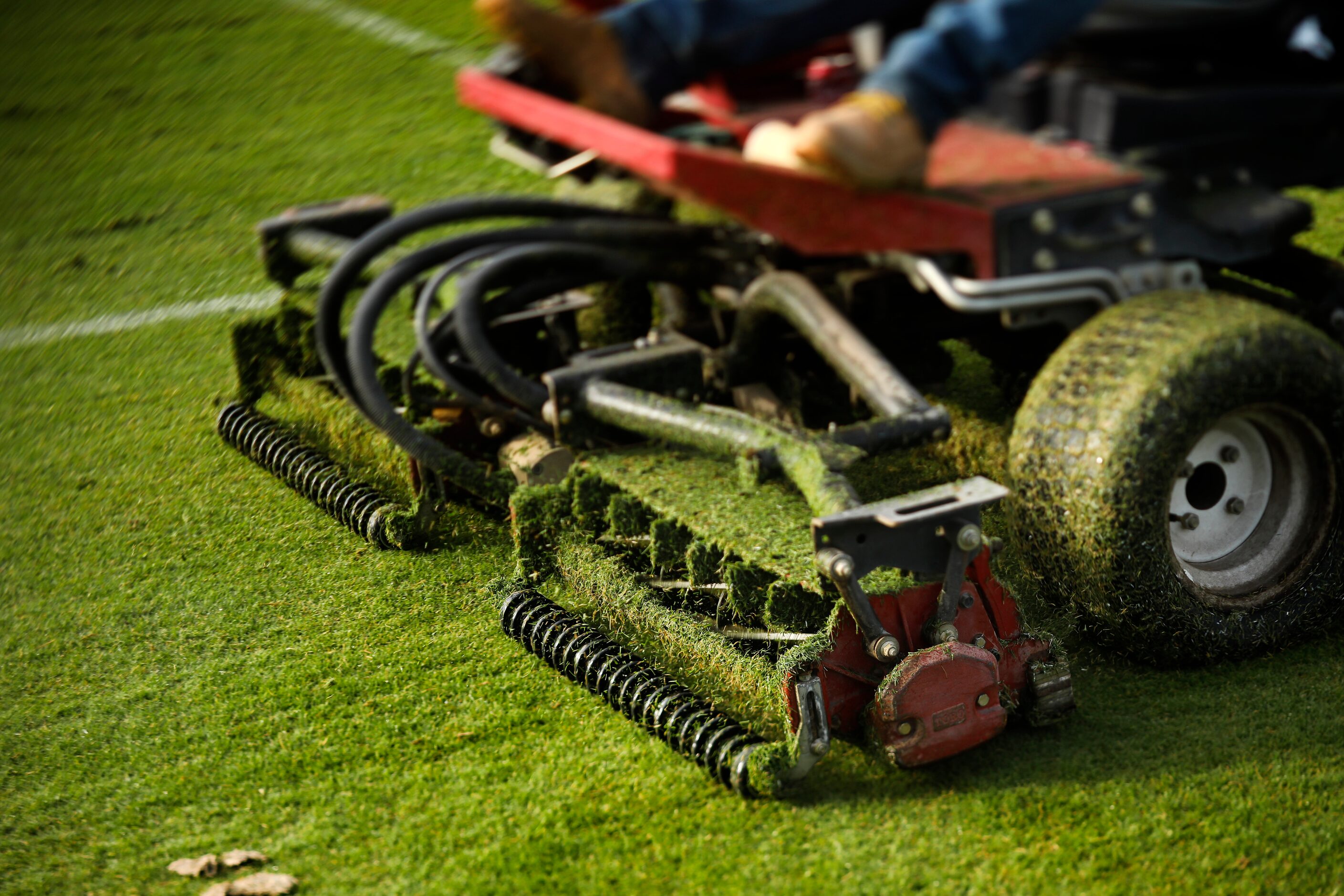 Grounds crewman cut the grass fields in preparation for the teams first practice, Thursday,...