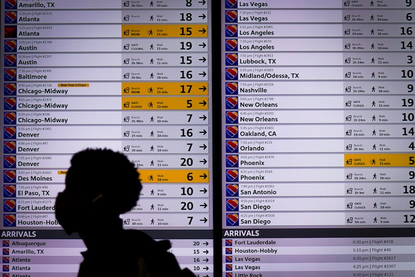 A man passes a flight status board at Love Field on Wednesday, Sept. 23, 2020, in Dallas. ...