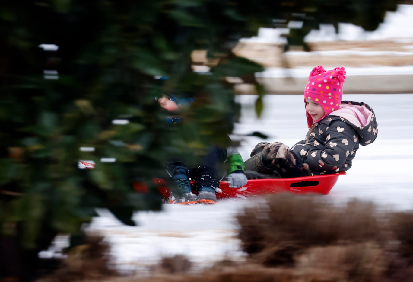 Cameron Wright and Ally Molaison (ride) are pulled around the sleet-covered streets on a...