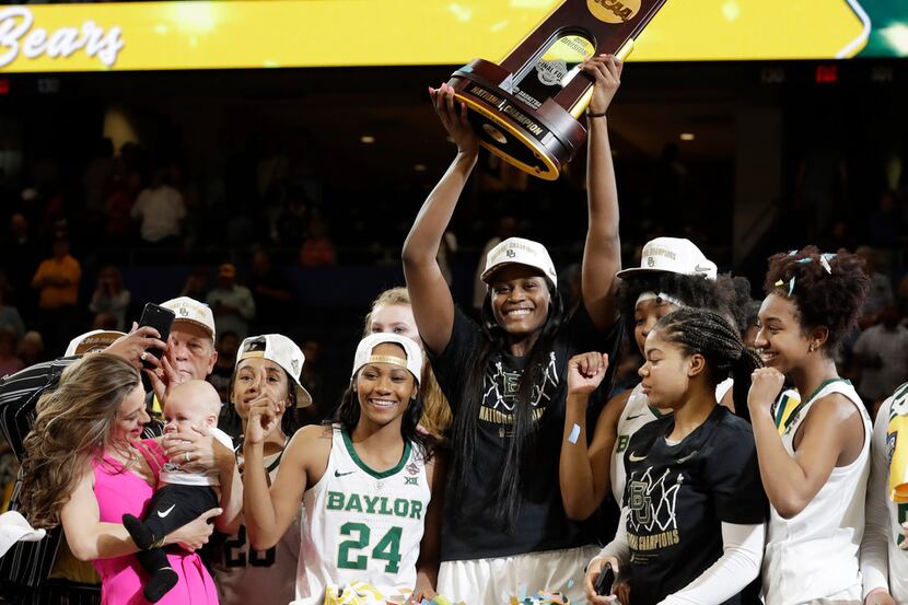 The Baylor team raises the NCAA championship trophy after defeating Notre Dame 82-81, at the...