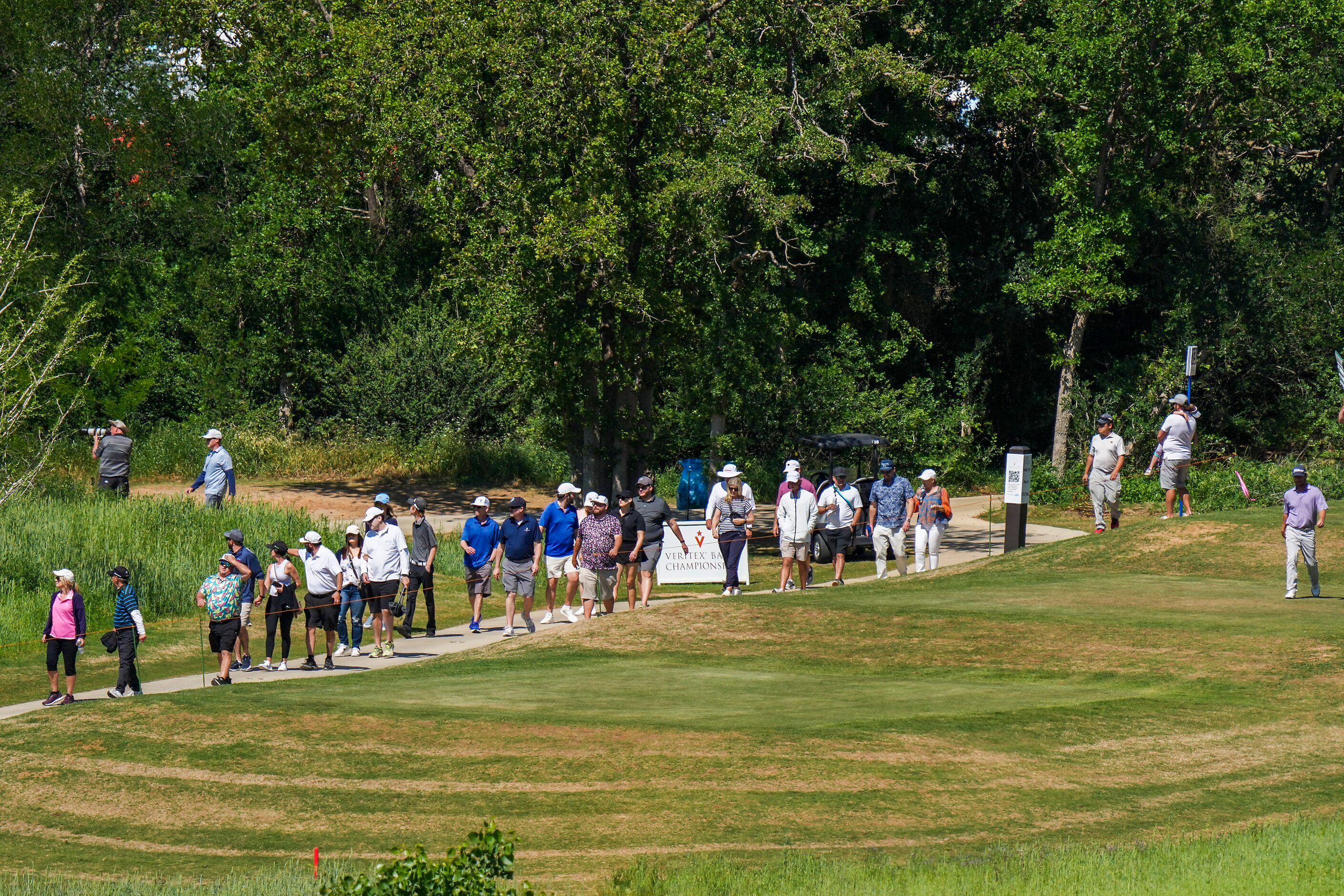 A gallery follows Spencer Levin (far right) up the fairway on the 13th hole during the final...