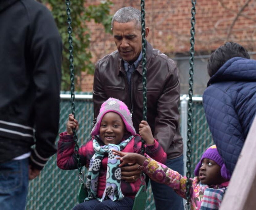 President Barack Obama pushes kids on the swings as they visit "Malia and Sasha's Castle,"...