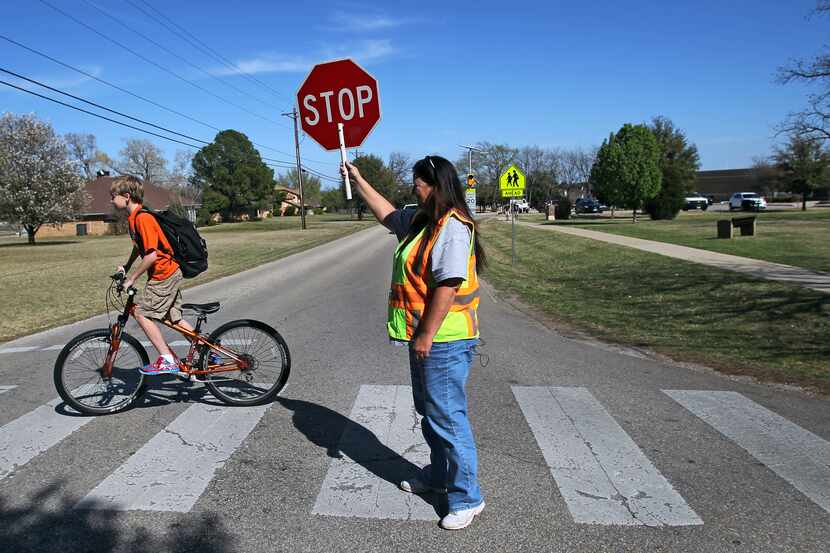 Crossing guard and longtime Double Oak resident Debbie Schmidt works the intersection of...