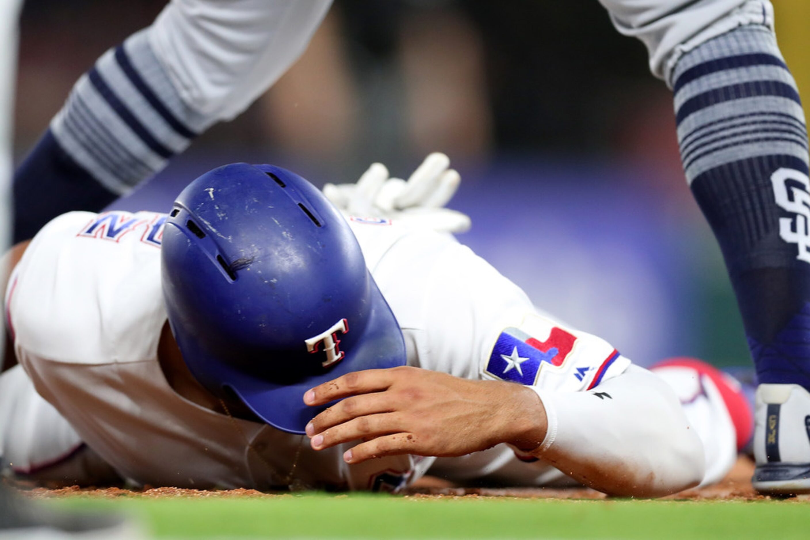 ARLINGTON, TX - JUNE 25:  Ronald Guzman #67 of the Texas Rangers reacts after colliding with...