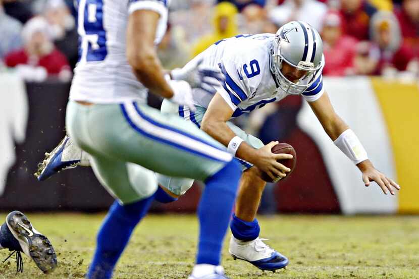 Dallas Cowboys quarterback Tony Romo stumbles on a play during the second half of Dallas'...