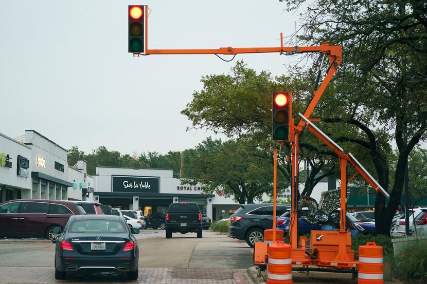 Temporary traffic signals are seen at a parking entrance on the northeast corner of the...