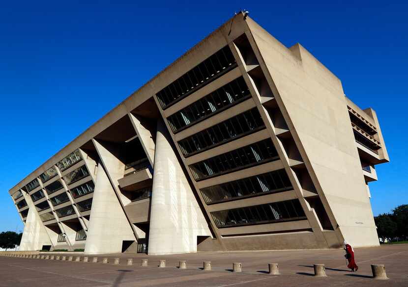 A woman walks through the large plaza that leads up to Dallas City Hall, (AP Photo/Tony...