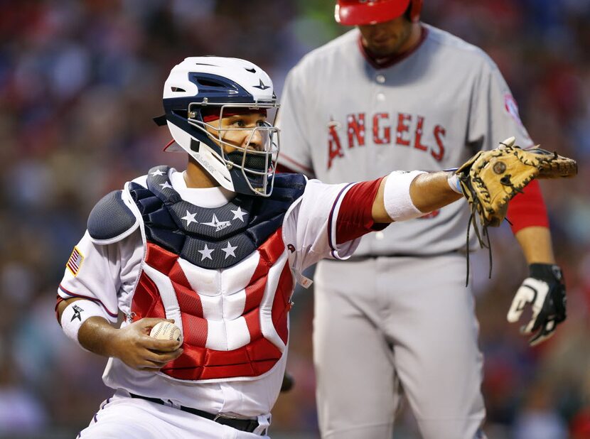 Texas Rangers catcher Carlos Corporan (3) sported a patriotic chest protector and helmet as...