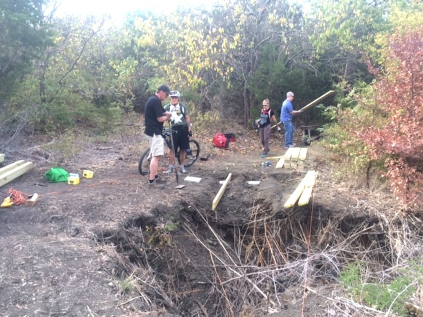 
Volunteers from the Dallas Off Road Bicycle Association work around a sink hole created by...