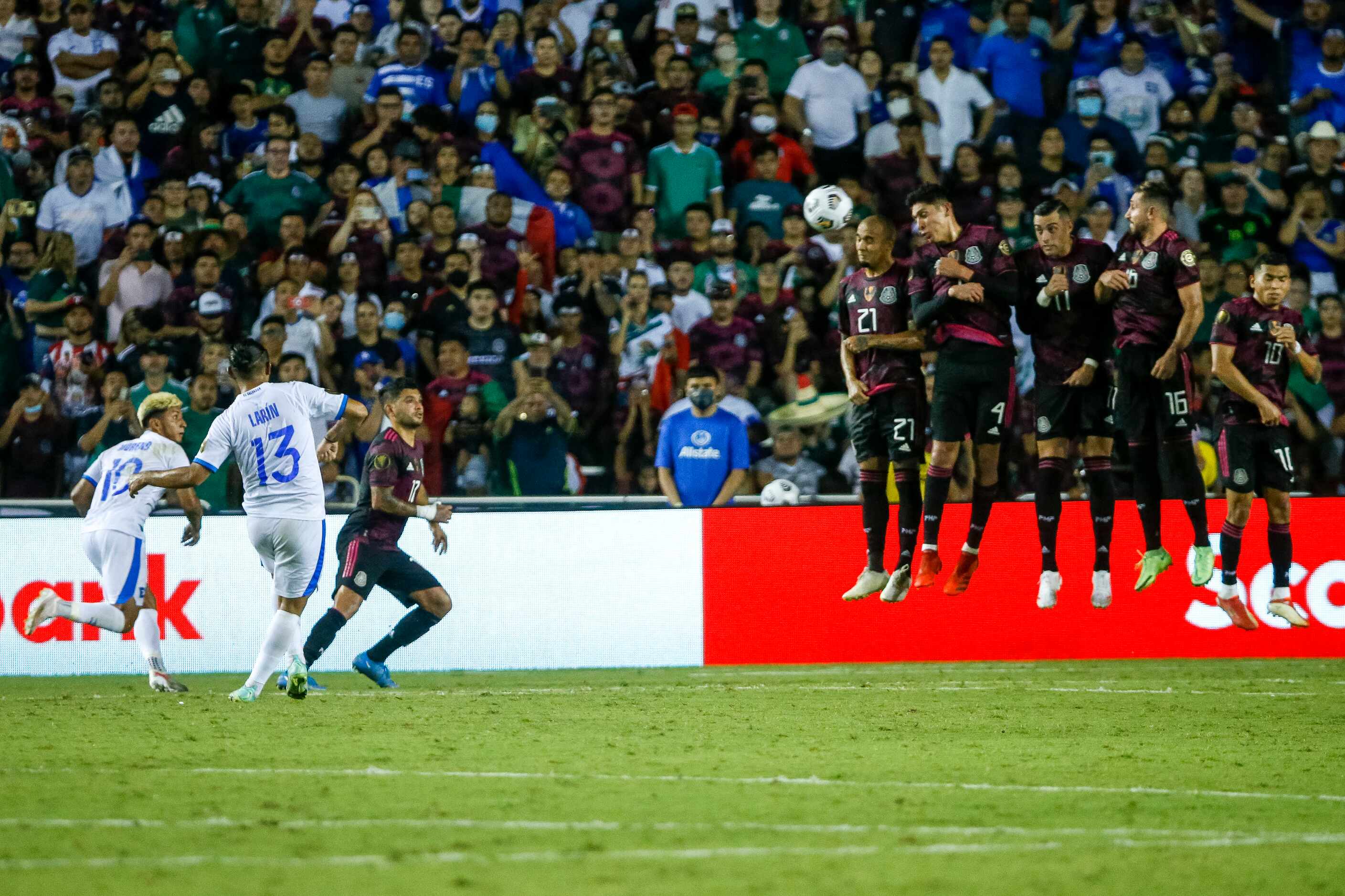 El Salvador defender Alexander Larín (13) attempts a free kick over the leaping wall of the...