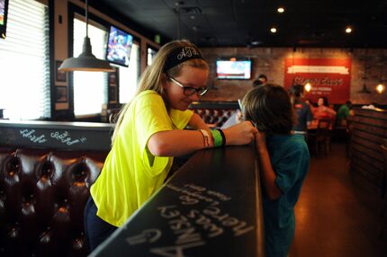 Ainsley Thiem and her brother Hagan participate in a Gino's tradition of writing on the...