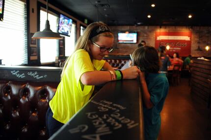 Ainsley Thiem and her brother Hagan participate in a Gino's tradition of writing on the...