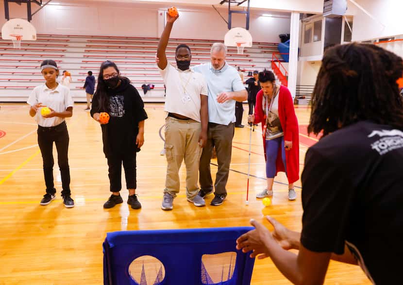 Lee Lee Robinson (right), an adapted PE teacher at Dallas ISD, claps to help guide visually...