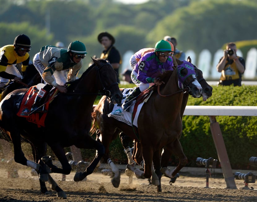 Victor Espinoza rides California Chrome (2) down the front stretch during the 2014 Belmont...
