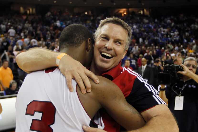 Flower Mound Marcus coach Danny Henderson hugs Marcus Smart (3) after beating Garland...
