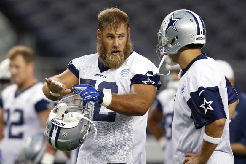 Dallas Cowboys quarterback Tony Romo (9) talks with Dallas Cowboys center Travis Frederick...