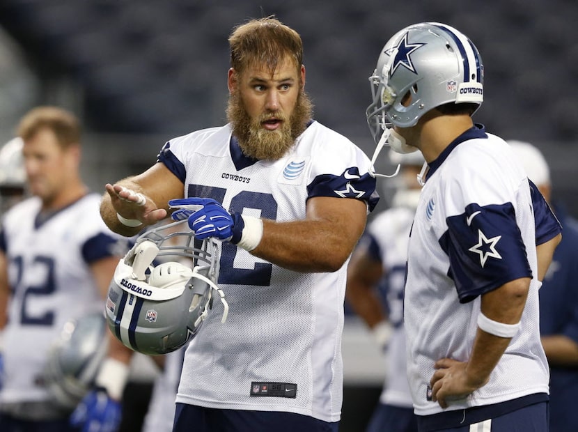 Dallas Cowboys quarterback Tony Romo (9) talks with Dallas Cowboys center Travis Frederick...