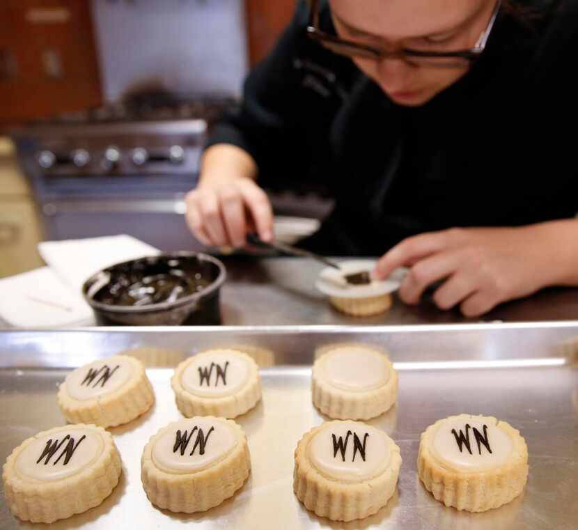 
Chef Gillean Williams stencils the Neiman Marcus logo onto shortbread cookies that Le...