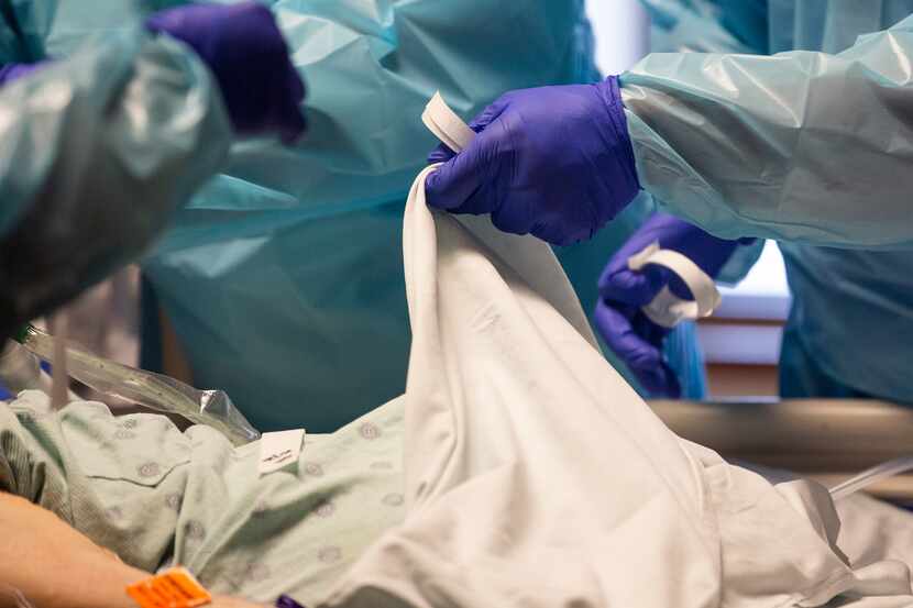 Certified registered nurse anesthetist Brandon Mitchell places a blanket over a patient...