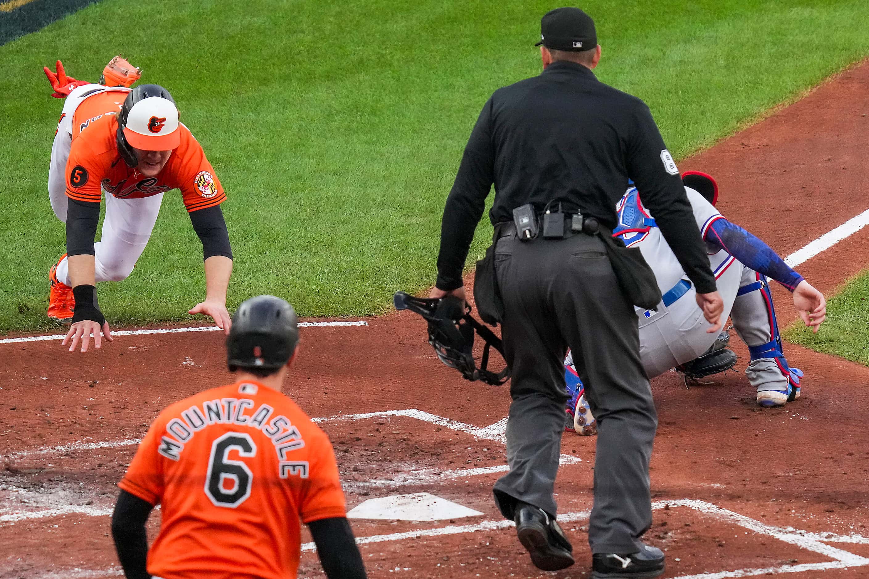 Baltimore Orioles third baseman Gunnar Henderson scores past Texas Rangers catcher Jonah...