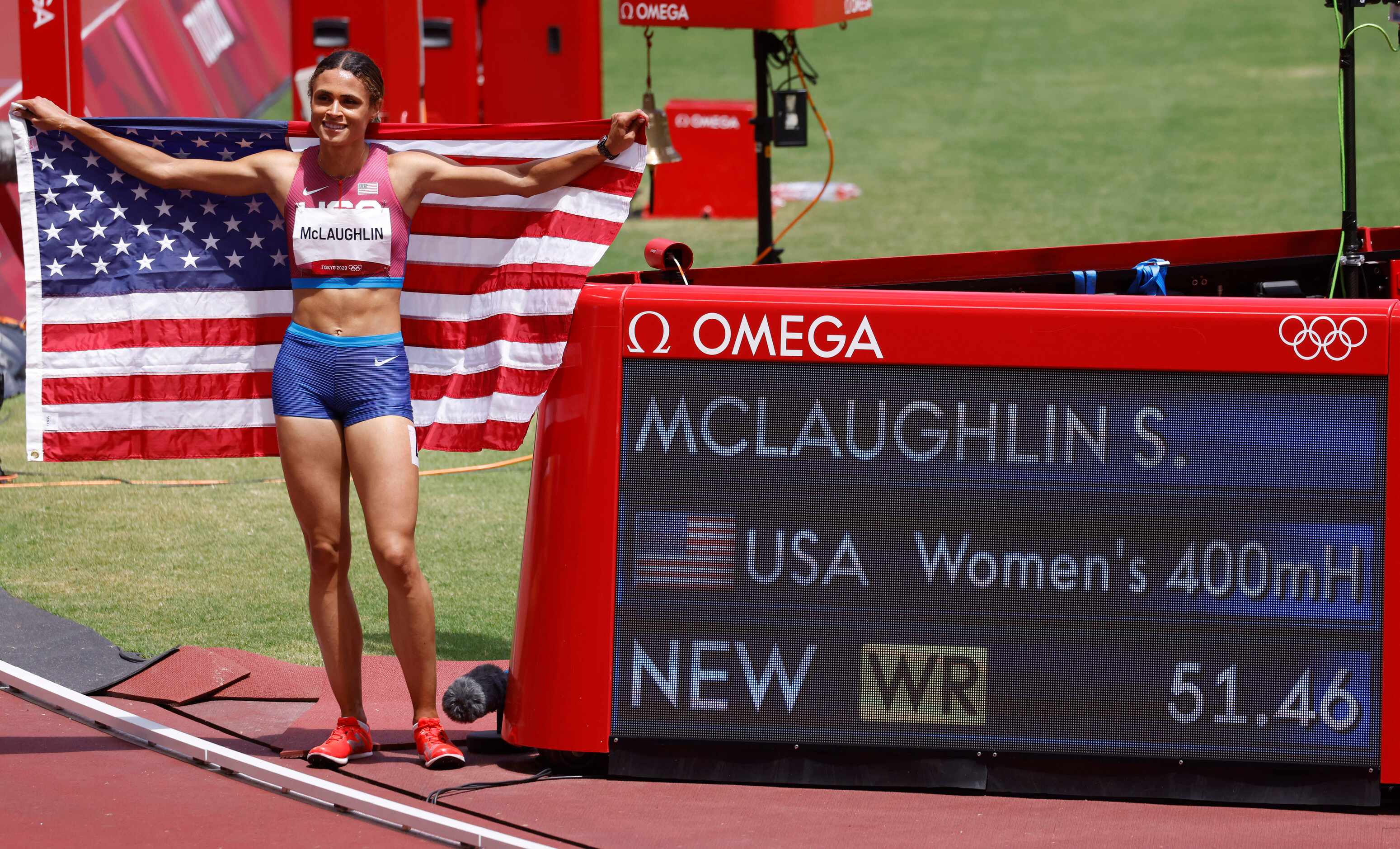 USA’s Sydney McLaughlin poses next to her world record time displayed across the screen...