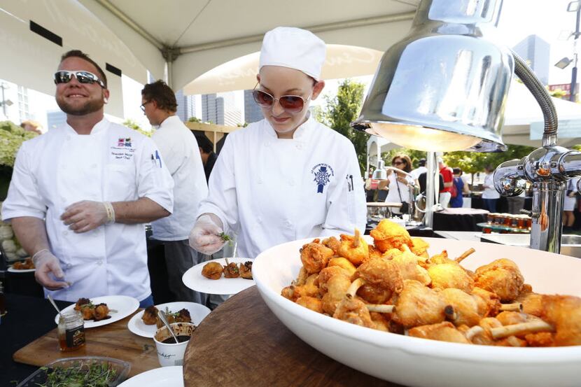 Central Market's Brandon McGee, left, and culinary student Daniele Johnston serve up a plate...