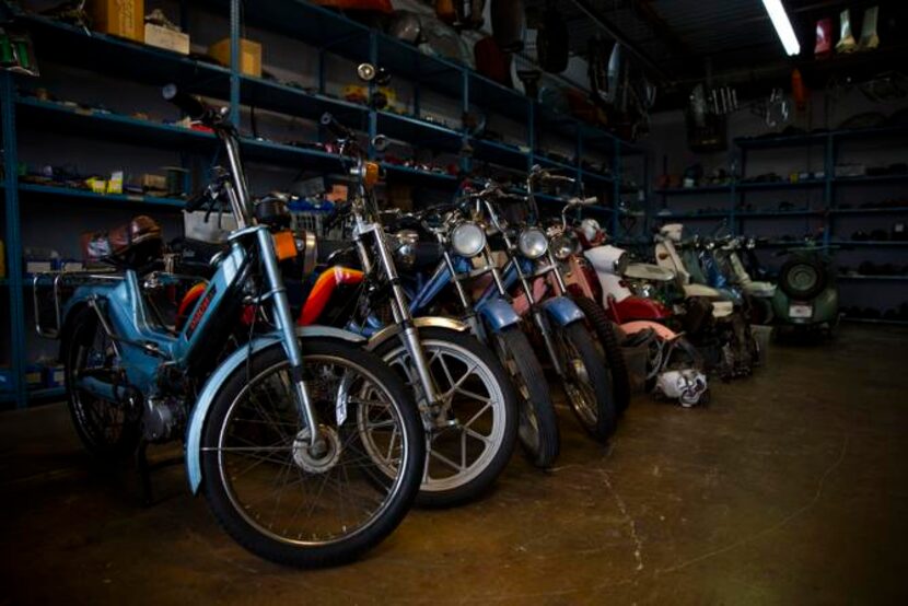 
Mopeds, scooters and motorcycles line the edge of the garage at Kyle's Scooter Shop, in...