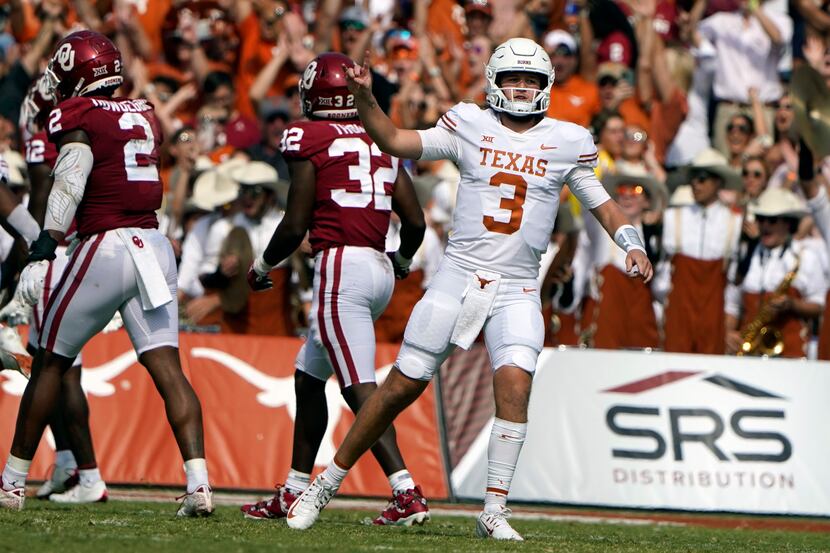 Texas quarterback Quinn Ewers celebrates throwing a touchdown pass as Oklahoma defenders (2)...