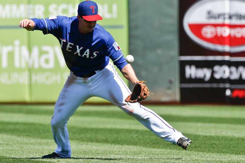 Texas Rangers second baseman Elliot Johnson bobbles the ball hit by Seattle Mariners' Carlos...