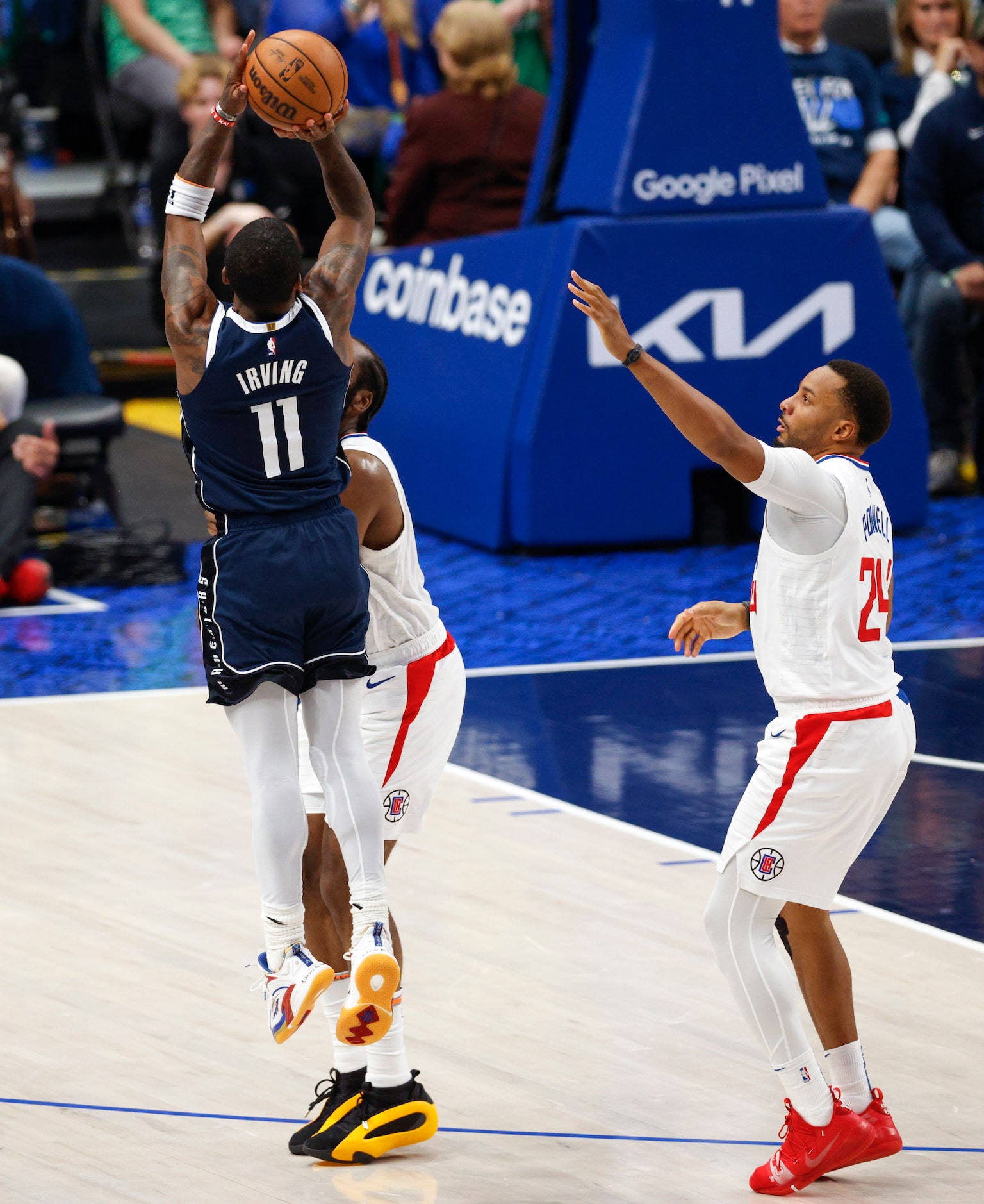 Dallas Mavericks guard Kyrie Irving (11) shoots over LA Clippers guard James Harden (1) and...