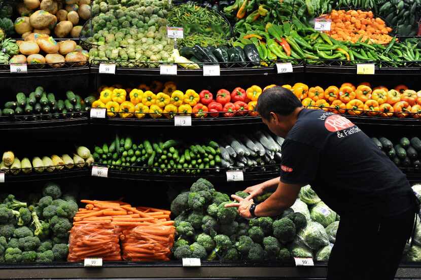 Produce clerk Frank Duenas arranges vegatables at the Ralph's grocery store in downtown Los...