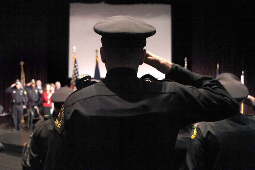  Graduates salute during a ceremony for the Dallas Police Department Basic Academy Recruit...