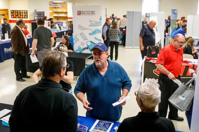 Mike Dovey talks to prospective employers during a job fair at the UAW Hall in Belvidere,...