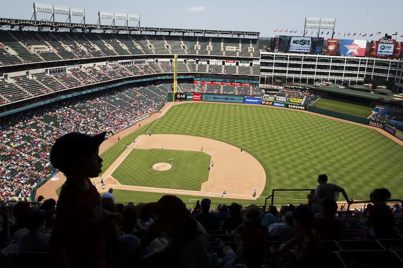 Texas Rangers fans find shade at the top of the stadium as they watch a game against the...