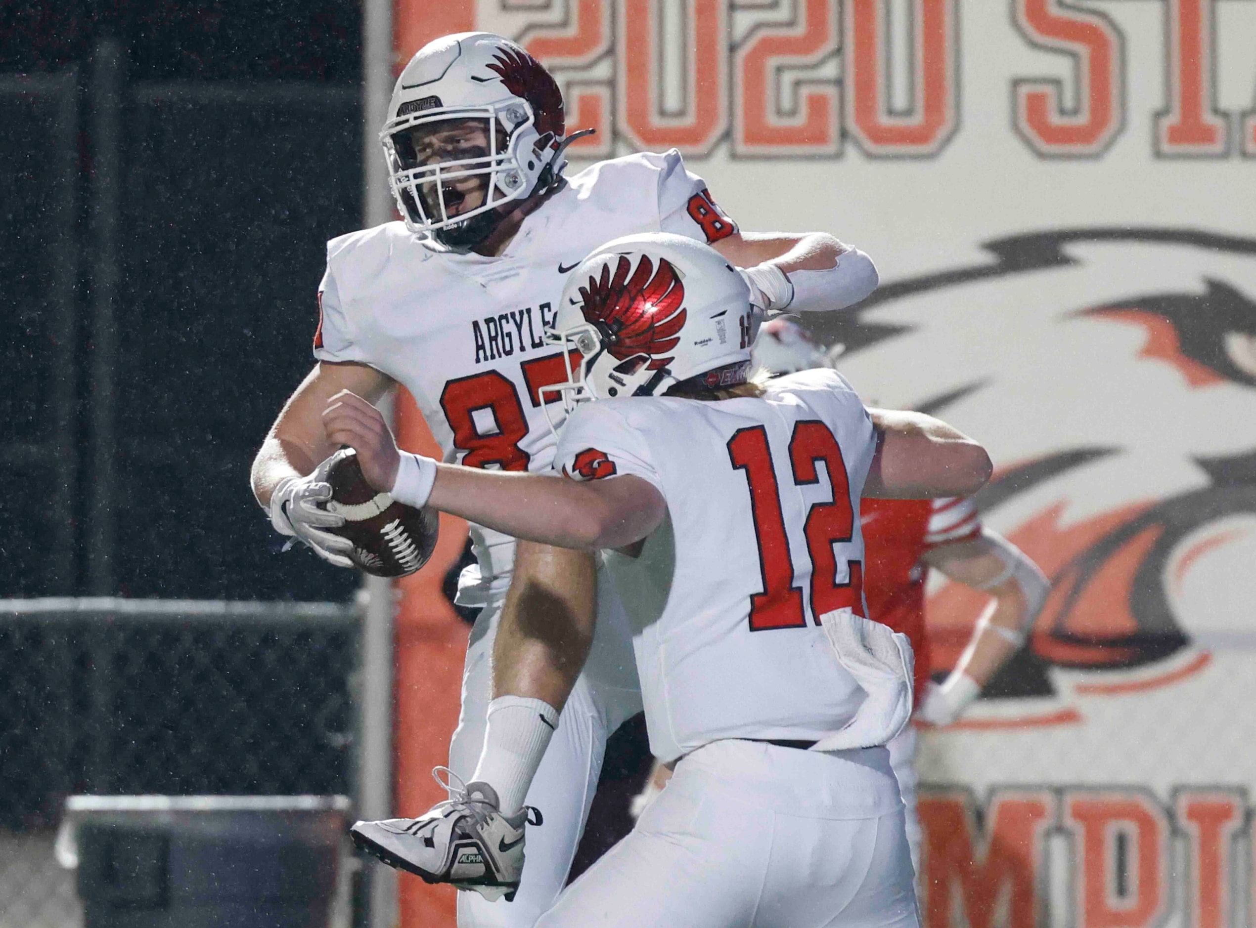 Argyle High’s Hunter McFaul (87), back, and Ezekiel Brown (12) celebrate a touchdown against...