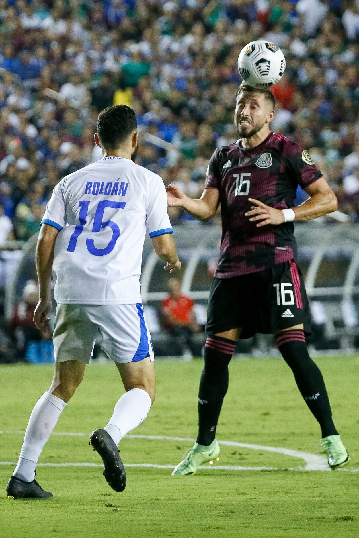 Mexico midfielder Héctor Herrera (16) heads the ball away from El Salvador midfielder...