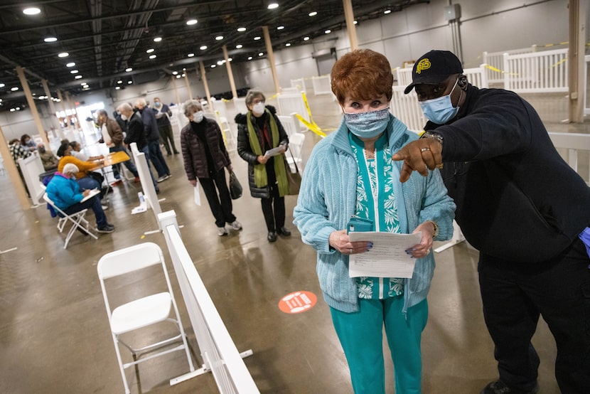 Lt. Clinton Page of Dallas Fire-Rescue instructs Brenda David, 75, where to wait for the...