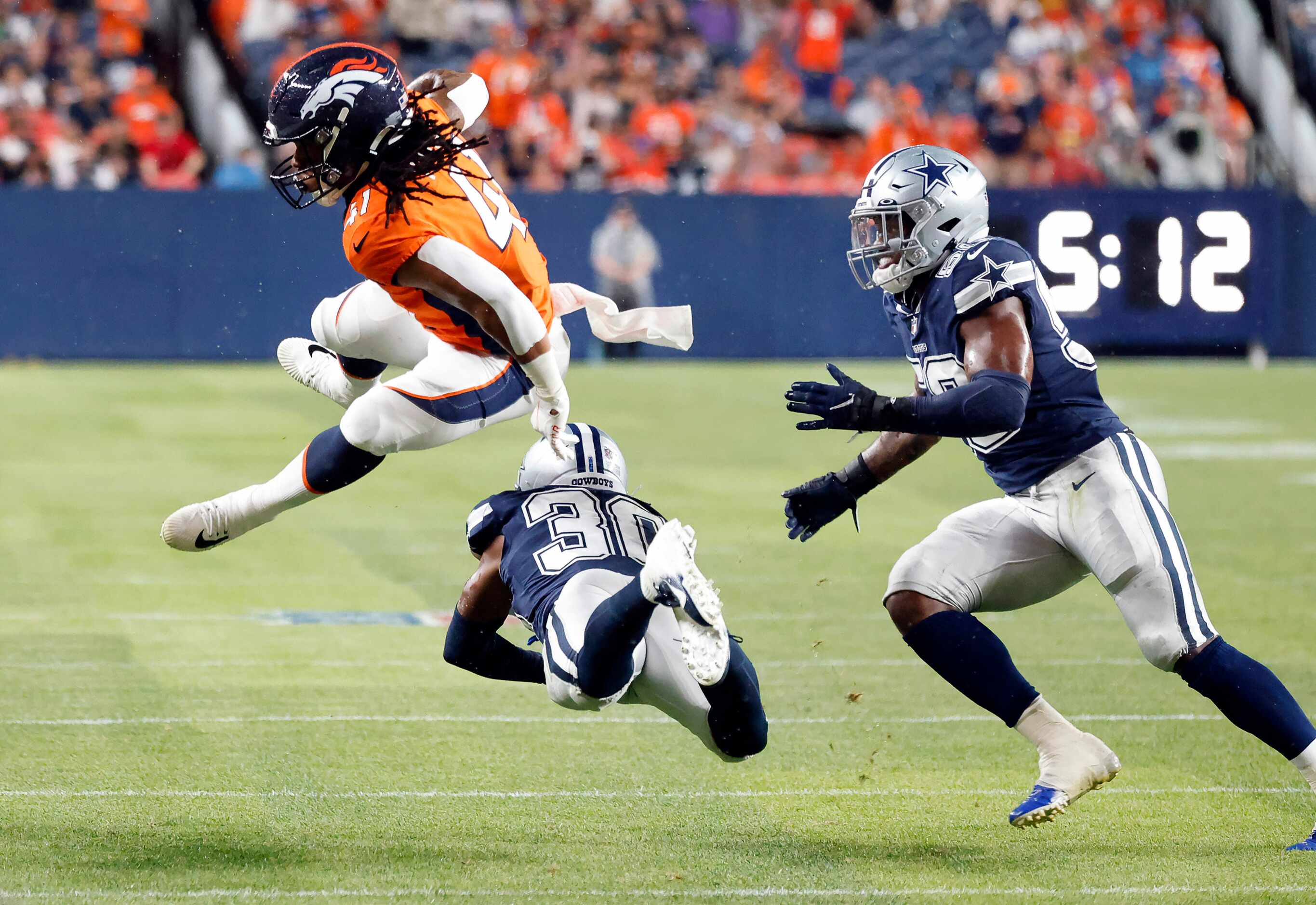 Denver Broncos safety Jamar Johnson (41) hurdles Dallas Cowboys cornerback DaRon Bland (30)...